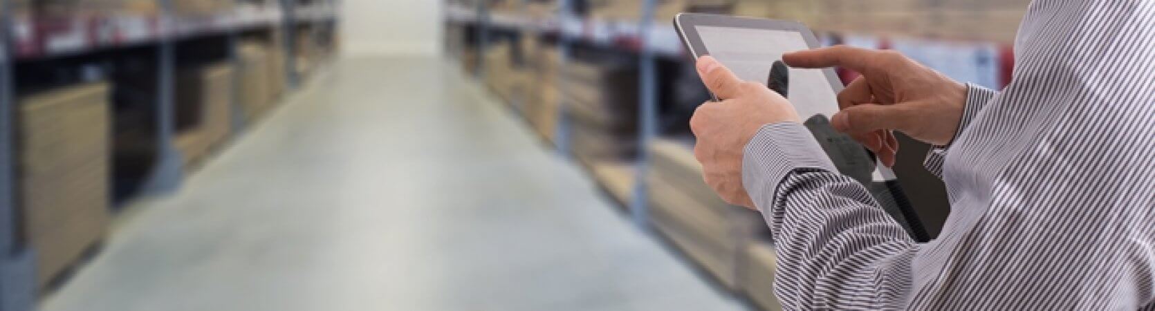 Warehouse businessman checking inventory on tablet.